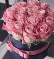 Розовые розы в черной шляпной коробке